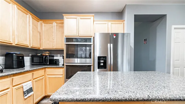 a kitchen with granite countertop a refrigerator and a stove
