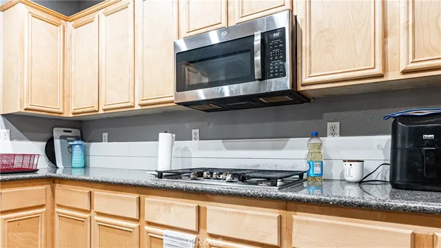 a kitchen with stainless steel appliances granite countertop a sink a stove and a microwave