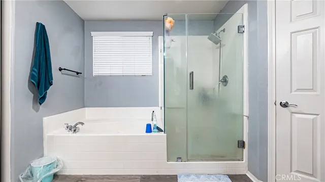a bathroom with a bathtub a shower and a window