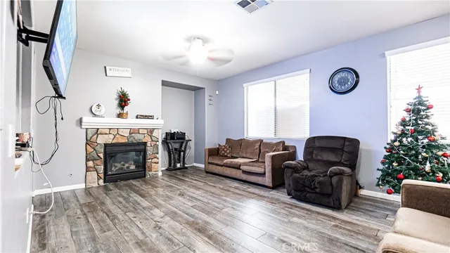 a living room with furniture a fireplace and a flat screen tv