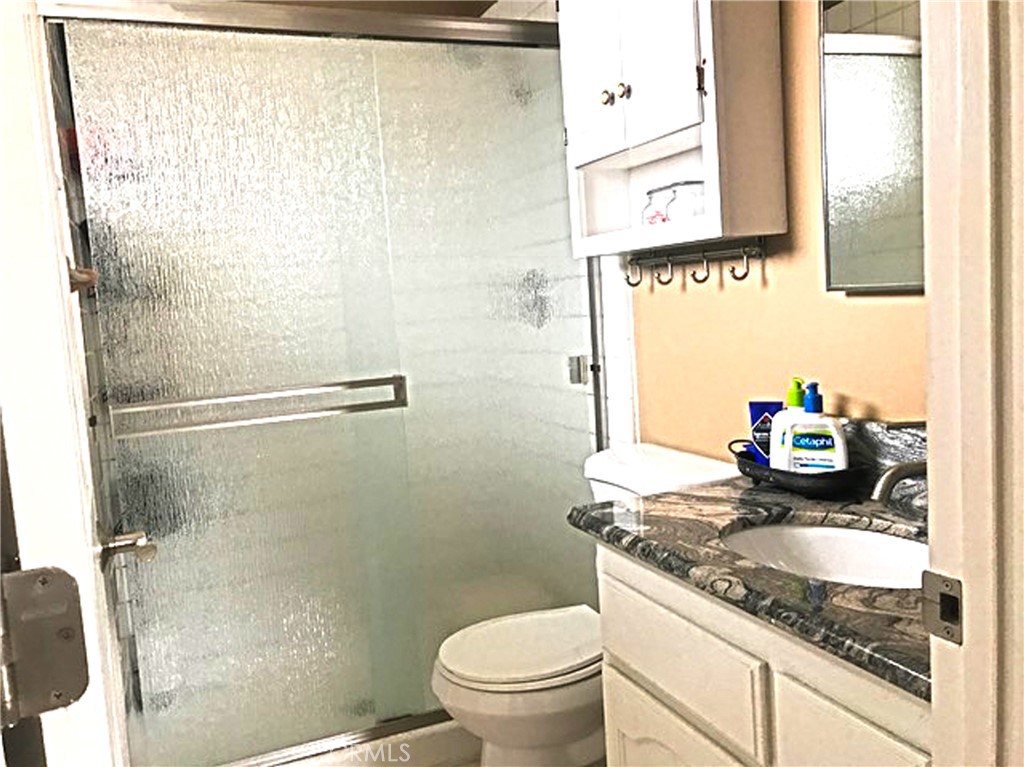 20011 Shorewood Circle Huntington Beach, CA 92646 - Photo 7 of 15 a bathroom with a granite countertop sink a toilet and a mirror