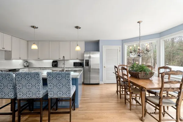 a kitchen with granite countertop a dining table chairs and white cabinets