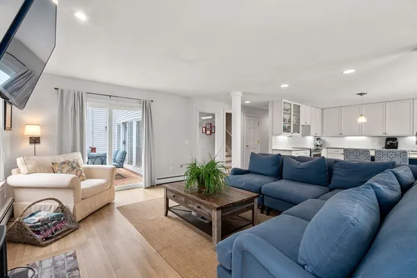 a living room with furniture and a view of kitchen