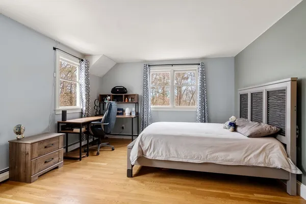 a bedroom with a bed and wooden floor