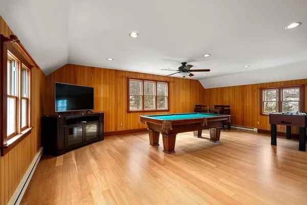 a room with furniture pool table flat screen tv and windows