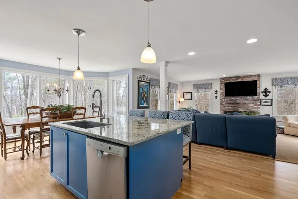 a kitchen with stainless steel appliances granite countertop a sink a stove and a wooden floors