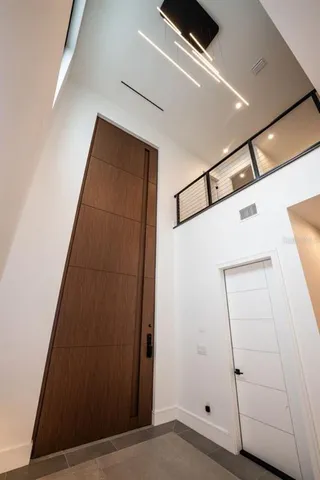a living room with furniture a flat screen tv and a refrigerator