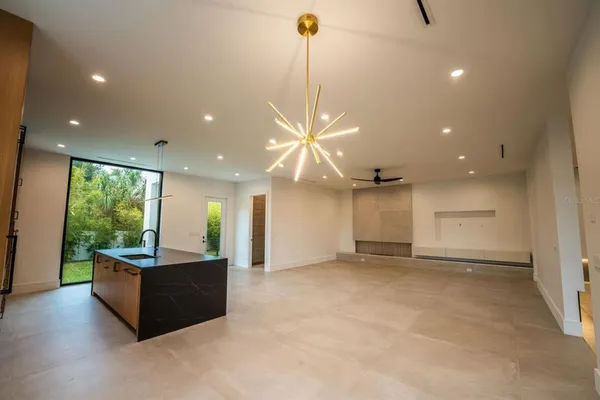 a view of a big room with wooden floor a ceiling fan and windows