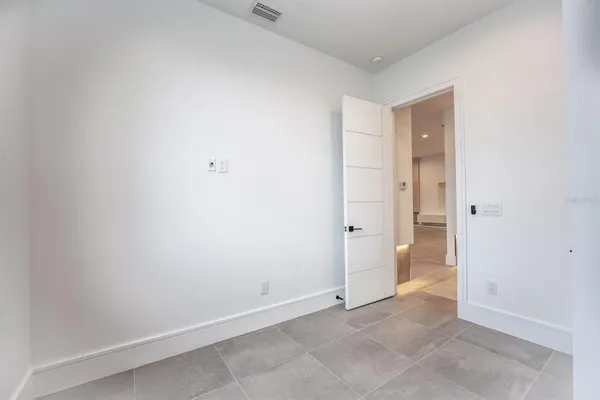 an empty room with a window and a ceiling fan