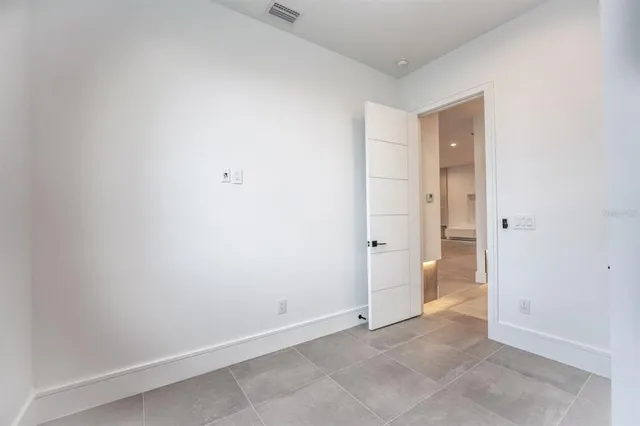 an empty room with a window and a ceiling fan