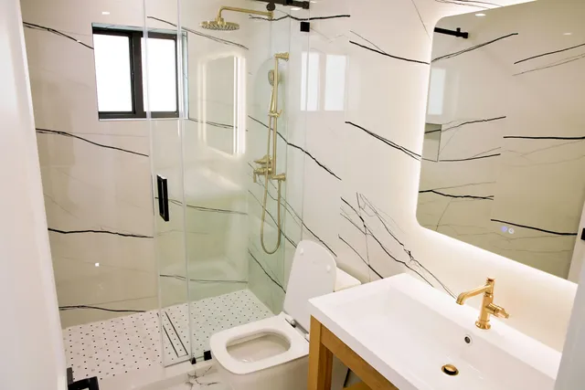 a bathroom with a sink a toilet and shower