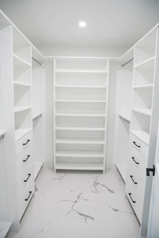 a view of walk in closet with empty racks
