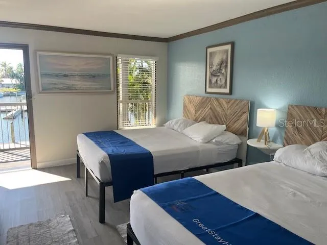 a bedroom with two beds and a large window