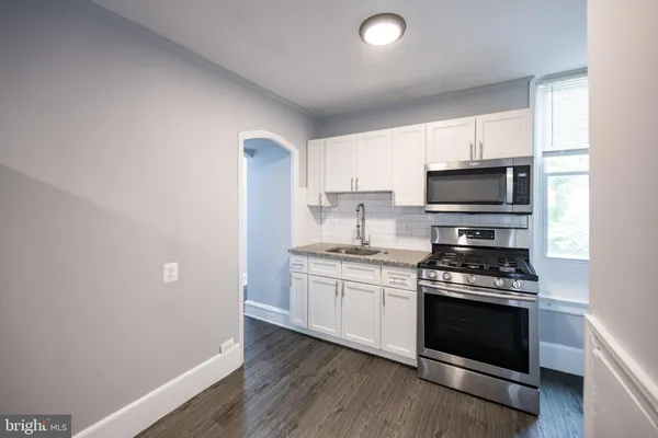 a kitchen with a sink a stove and microwave