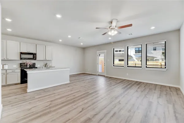 a view of kitchen with wooden floor electronic appliances and window