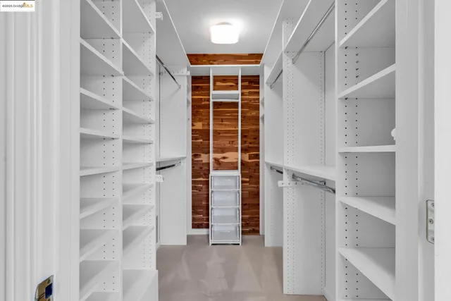 a view of walk in closet with empty racks