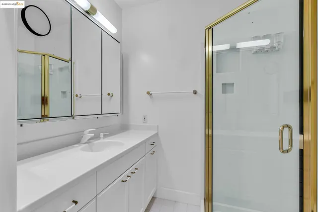 a bathroom with a granite countertop sink a mirror and a shower