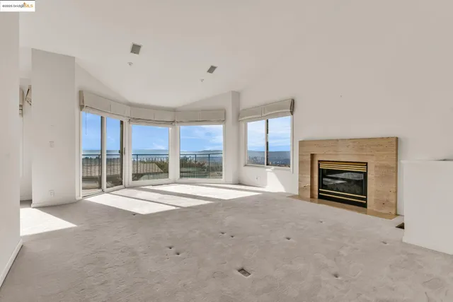 a view of an empty room with a fireplace and a large window