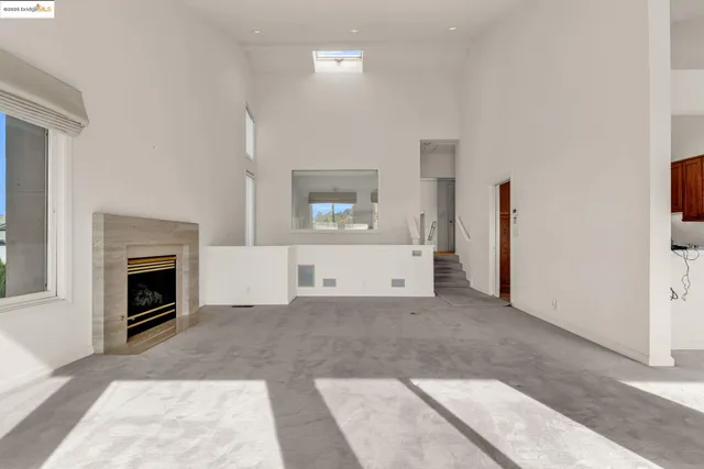 a view of a livingroom with a fireplace cabinet and windows