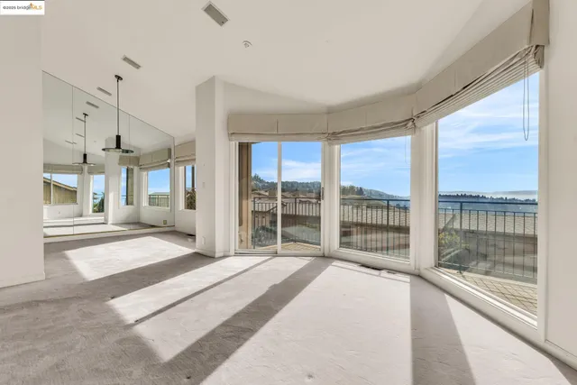 a bedroom with a bed and large windows