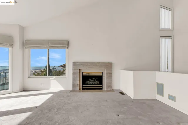 a view of an empty room with a fireplace and a window