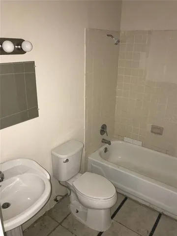 a white toilet sitting next to a bath tub