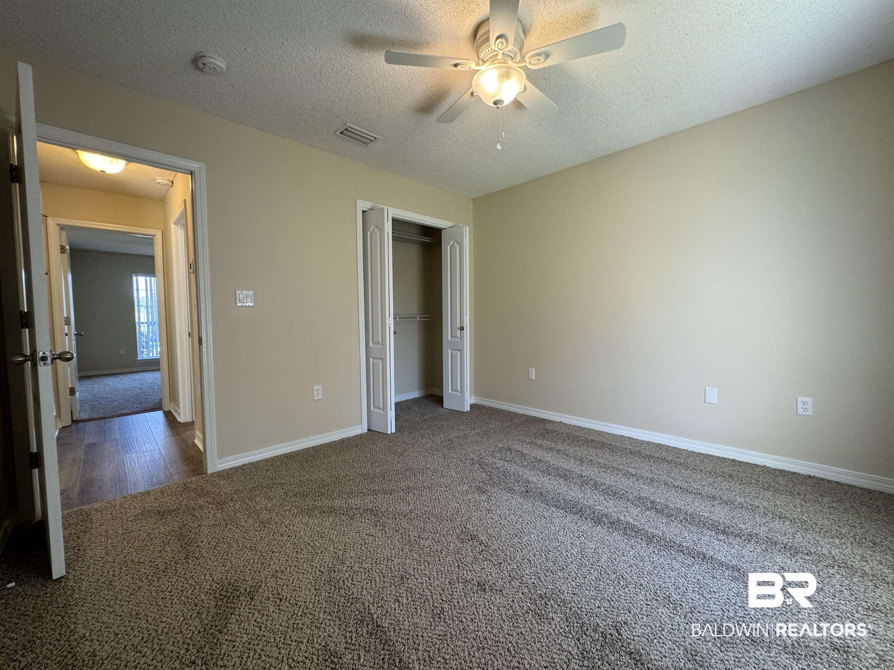 32769 Arbor Ridge Circle Lillian, AL 36549 - Photo 20 of 36 Unfurnished bedroom featuring ceiling fan, a textured ceiling, a closet, and dark carpet