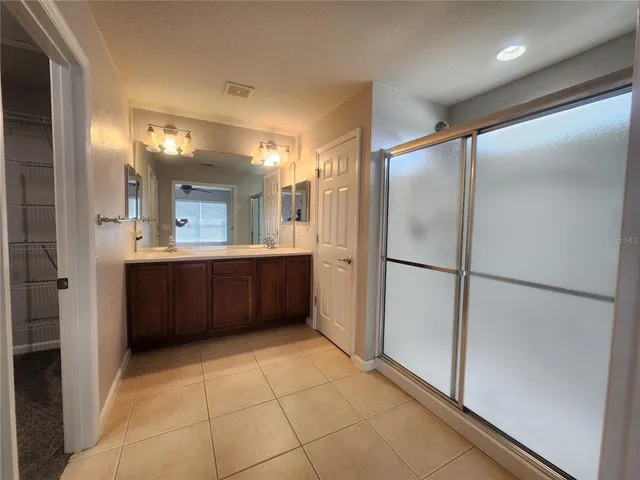 a bathroom with a double vanity sink a mirror and a shower