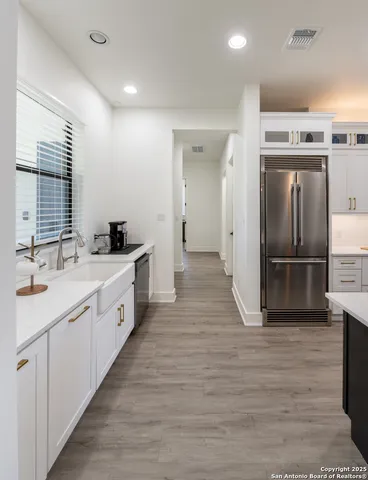 a large kitchen with kitchen island a large counter top space a sink stainless steel appliances and cabinets