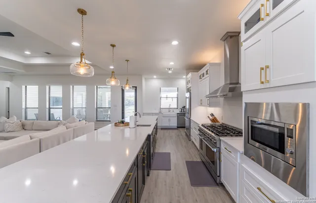 a kitchen with refrigerator a stove and wooden floor