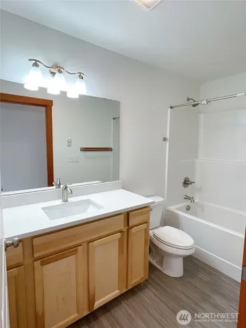 a bathroom with a sink a toilet a mirror and shower