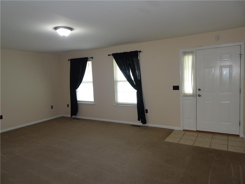 A welcoming entry on first floor with tiled entry and a cozy, carpeted living space.