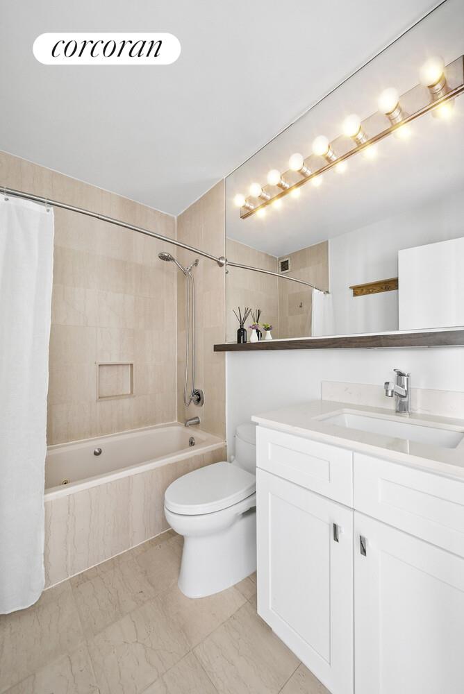 455 East 86th Street, Unit 11AB Manhattan, NY 10028 - Photo 12 of 15 a bathroom with a granite countertop sink a toilet a mirror and bathtub