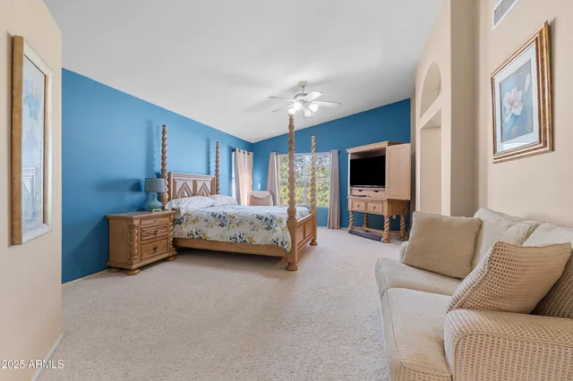 a bedroom with furniture and a flat screen tv