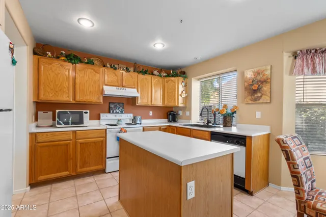 a kitchen with a sink a stove a refrigerator and cabinets