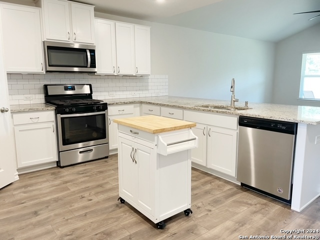 5015 Dancing Gopher San Antonio, TX 78261 - Photo 4 of 43 a kitchen with granite countertop a sink and a stove top oven