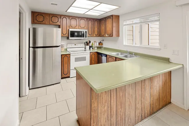 a kitchen with stainless steel appliances granite countertop a refrigerator sink and cabinets