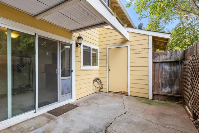 a view of backyard with barbeque grill and wooden fence