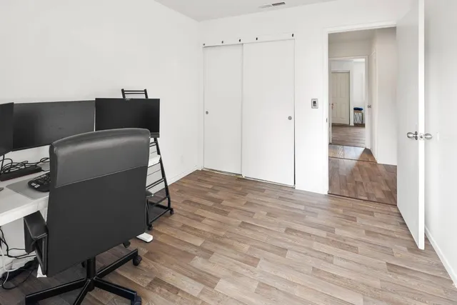 a view of a workspace with furniture and a window