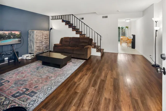 a living room with furniture and a wooden floor