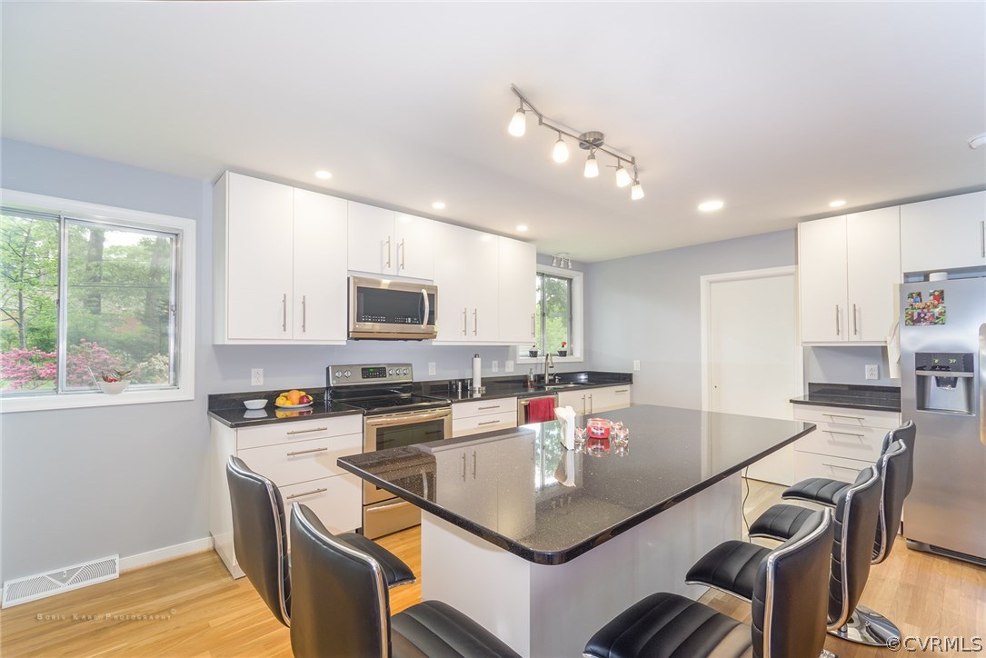 2307 Cranbrook Road Henrico, VA 23229 - Photo 3 of 18 a kitchen with a stove a sink dishwasher a dining table and chairs with wooden floor