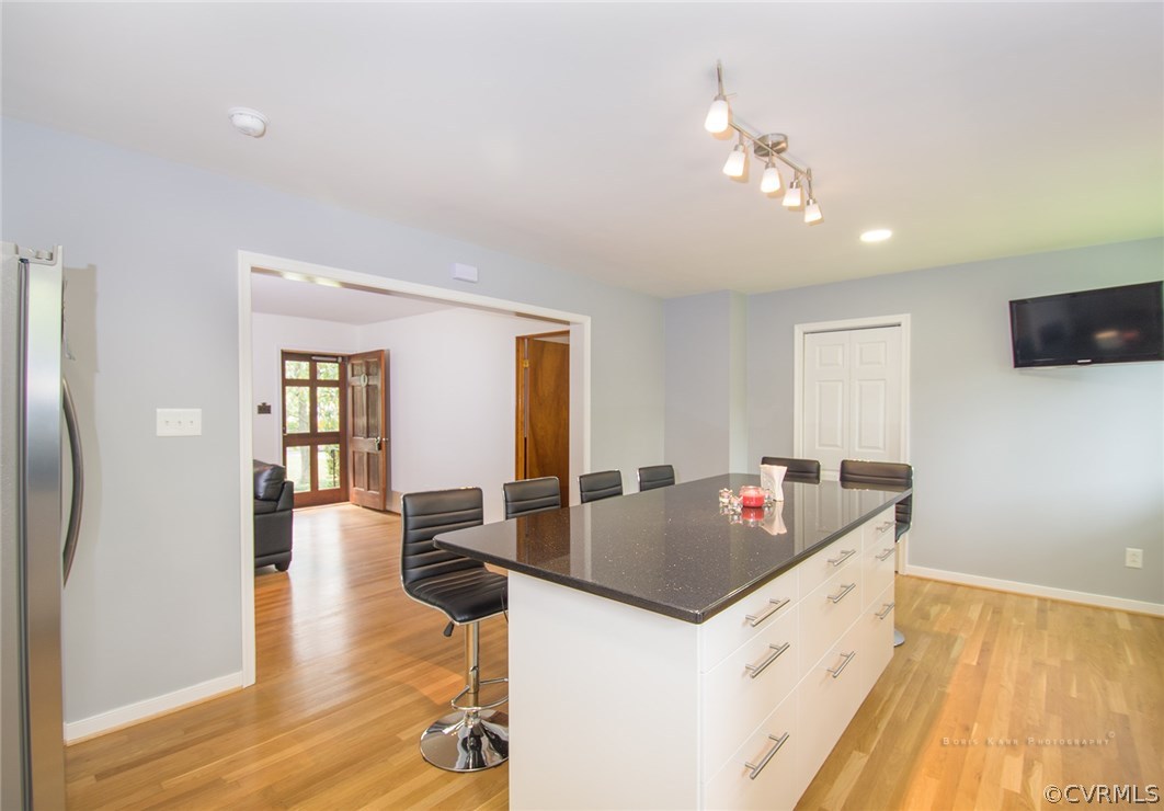 2307 Cranbrook Road Henrico, VA 23229 - Photo 6 of 18 a kitchen island with granite countertop a sink dishwasher refrigerator a dining table and chairs with wooden floor