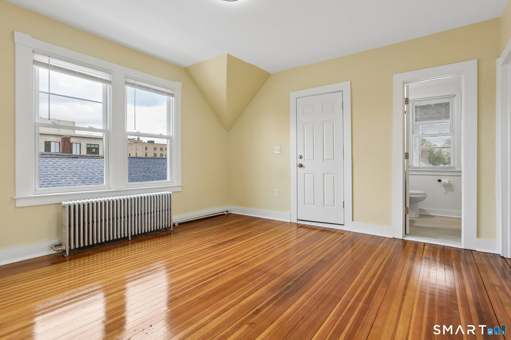 39 Grand Street, Unit 3 Middletown, CT 06457 - Photo 6 of 21 a view of an empty room with wooden floor and a window