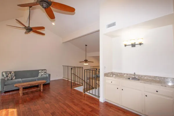 a view of a room with wooden floor and fan