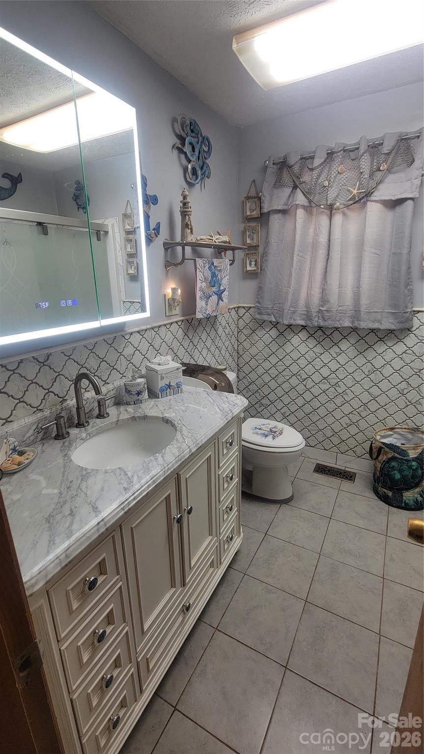 1082 Maple Street Granite Falls, NC 28630 - Photo 12 of 25 a bathroom with a granite countertop sink a toilet and a mirror