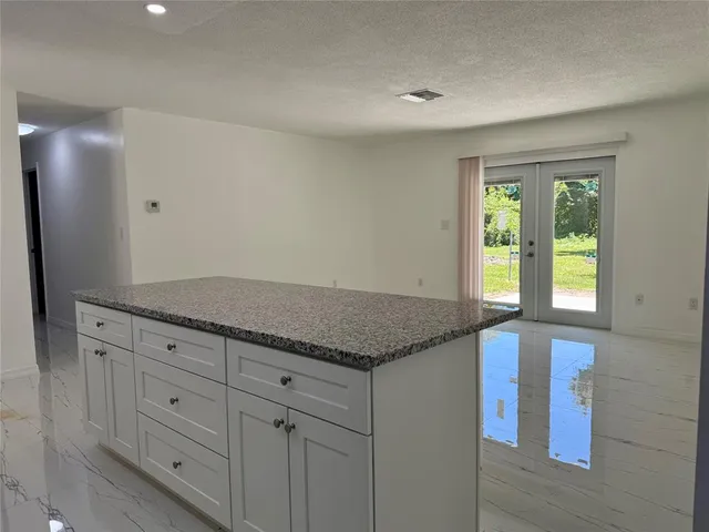 a view with granite countertop cabinets and window