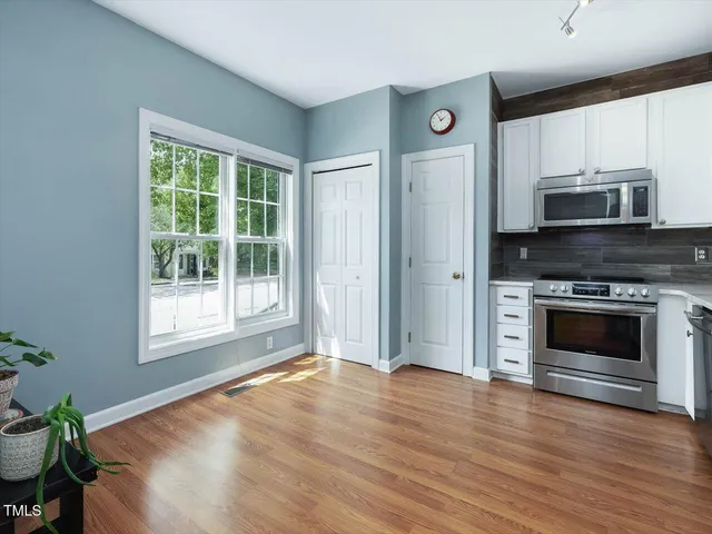 a view of empty room with wooden floor and fireplace