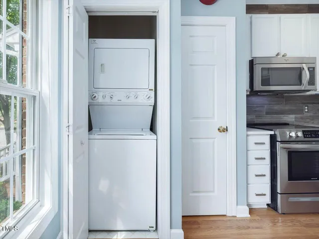 a view of a hallway with wooden floor and closet
