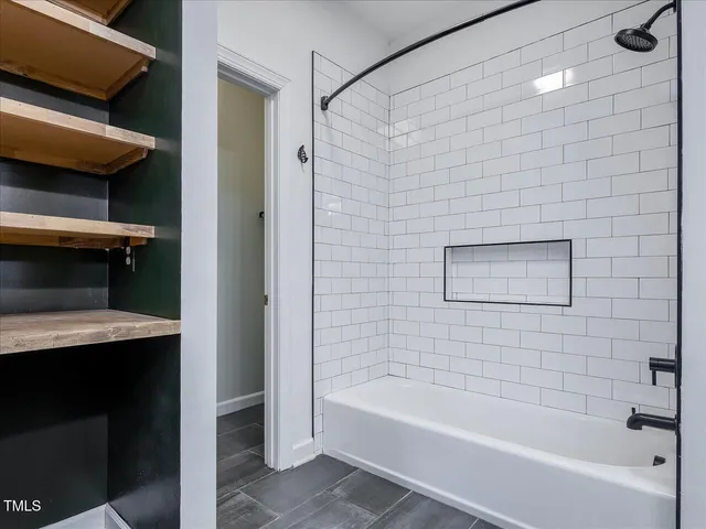 a view of hallway with walk in closet and bathroom