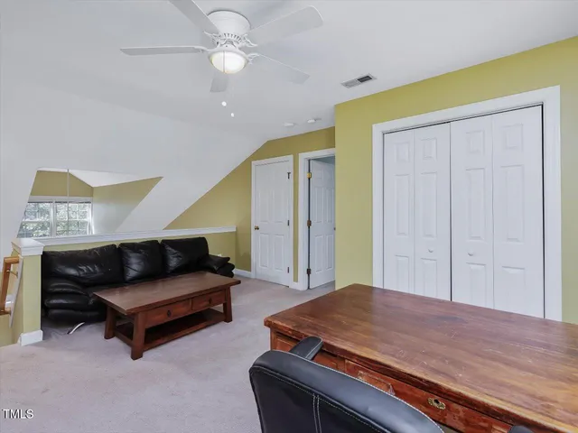 an empty room with a window and a fan